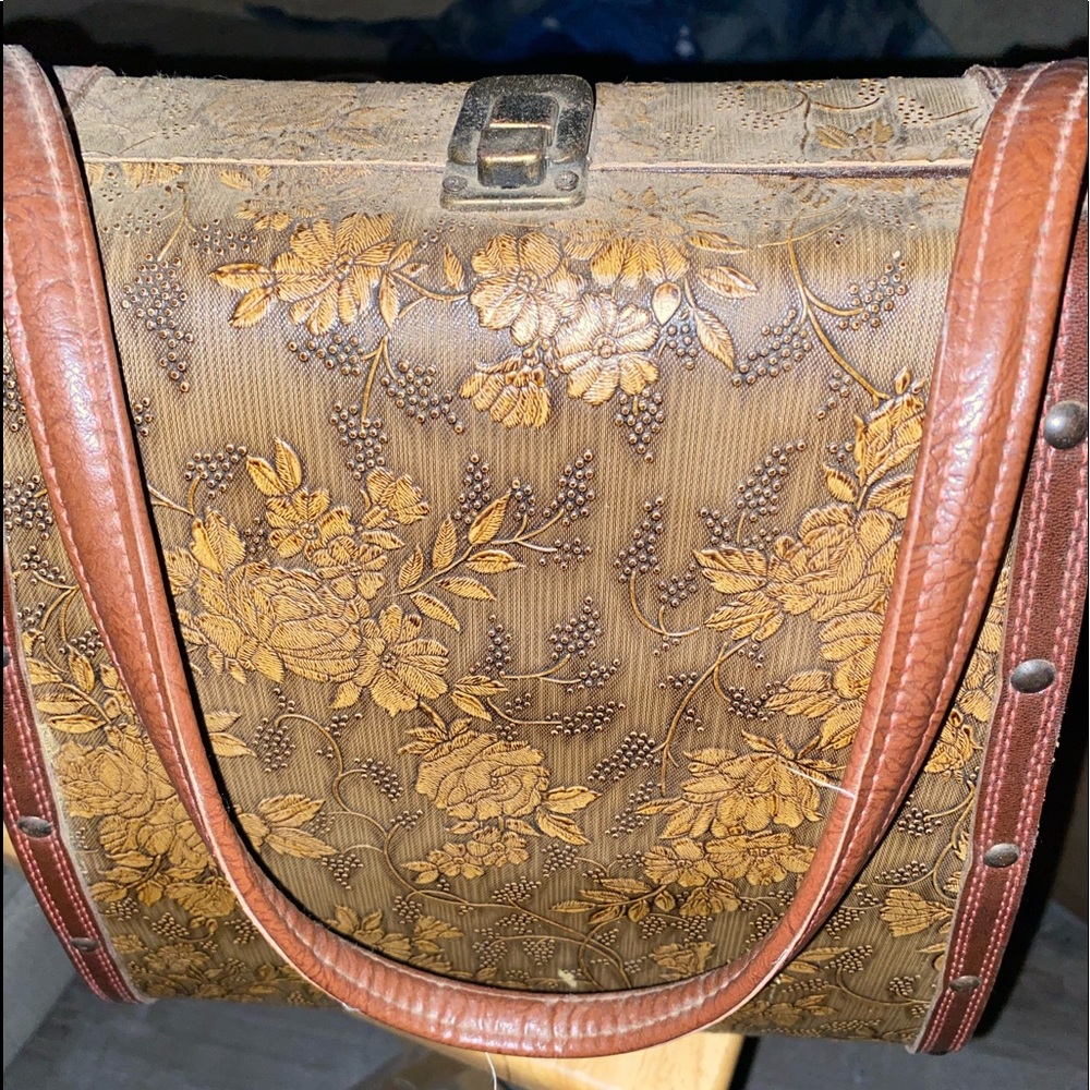 Decorative latched hard flowered box with strap.